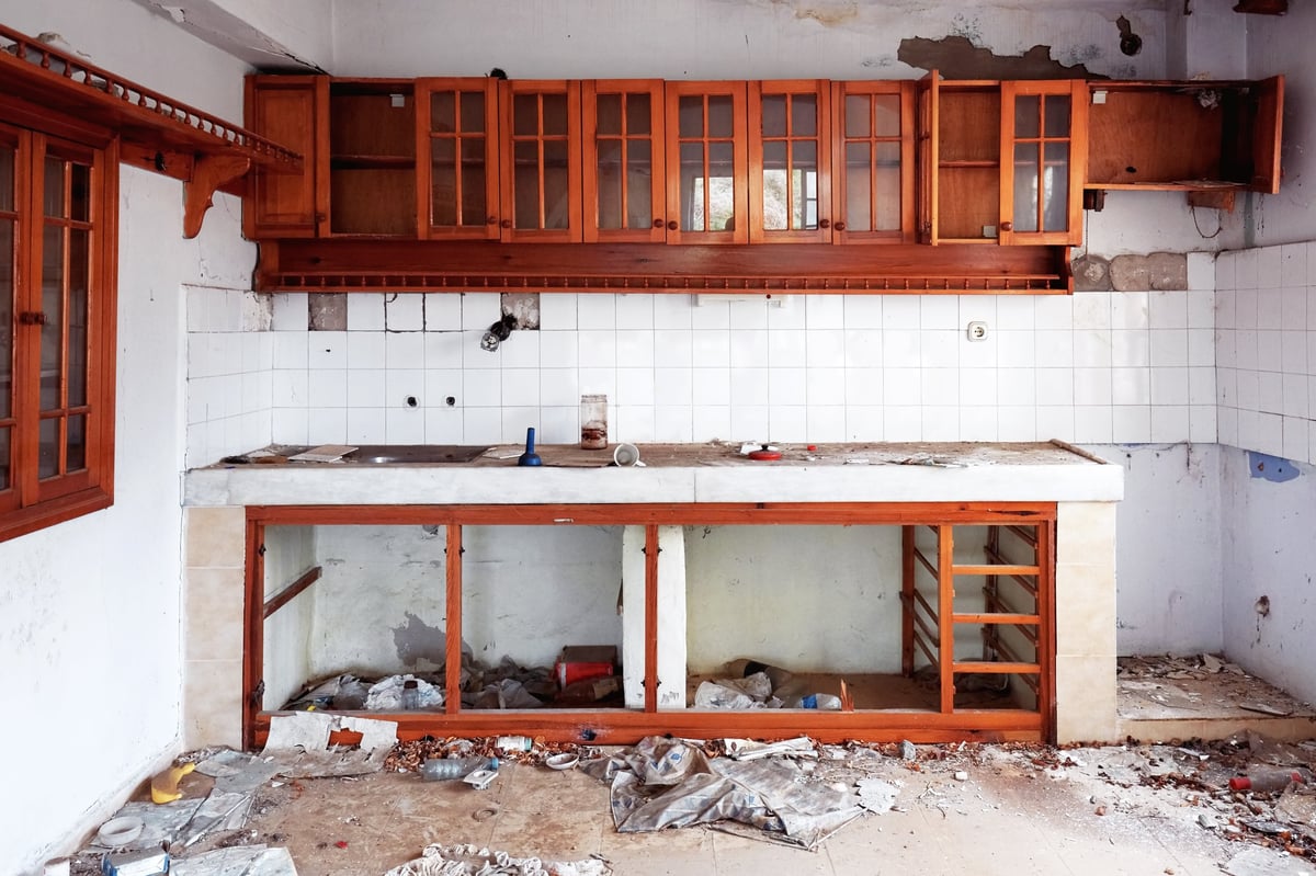 Empty gutted abandoned kitchen with old appliance