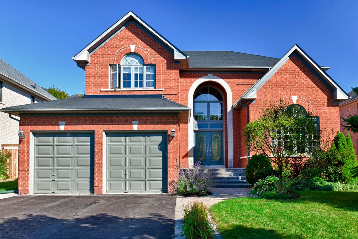 Older two story brick home in suburbs with two car garage