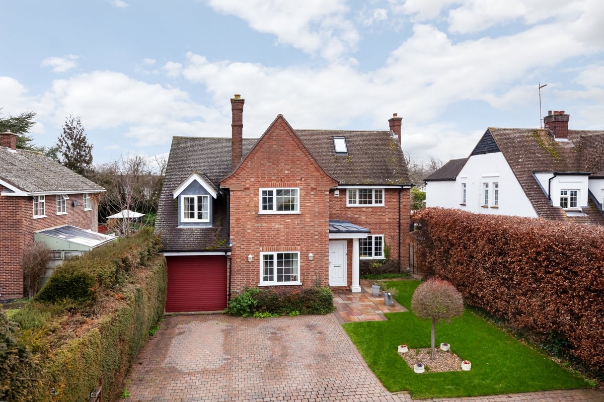 Traditional detached brick built suburban house with driveway and lawned garden