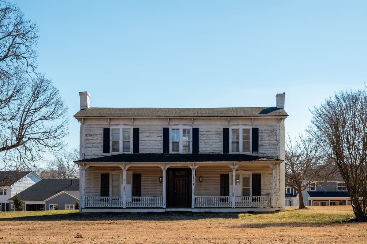 Old white wooden two story home in Belmont, North Carolina, needs work